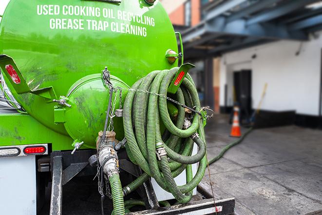 a grease trap being pumped by a sanitation technician in Lawrence